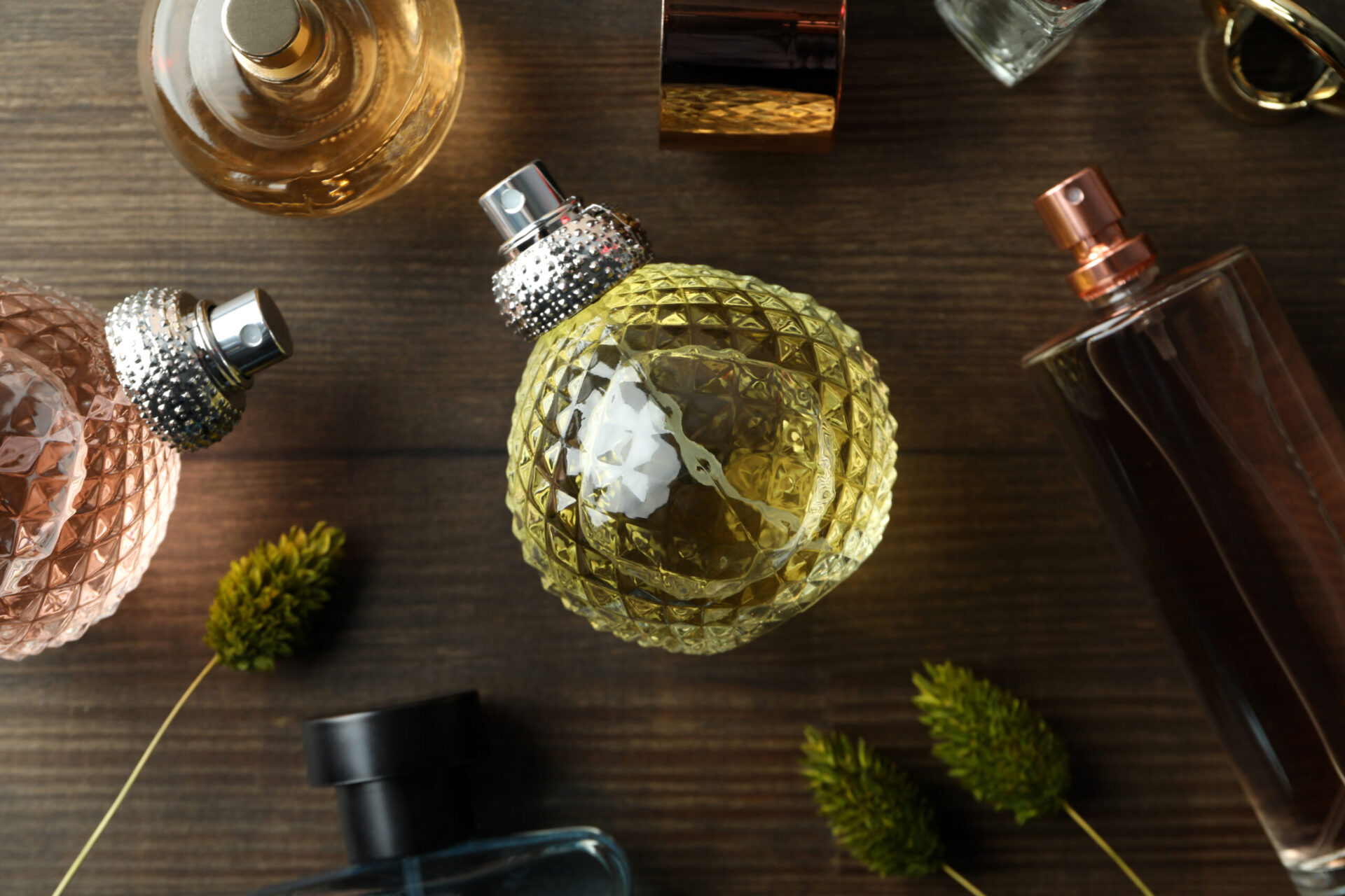 bottles of perfumes on wooden background top view 2023 11 27 05 15 38 utc scaled